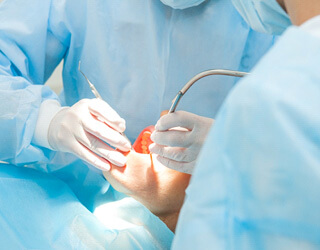 dentist performing a dental implant surgery