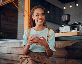 Smiling woman sitting on barstool at restaurant